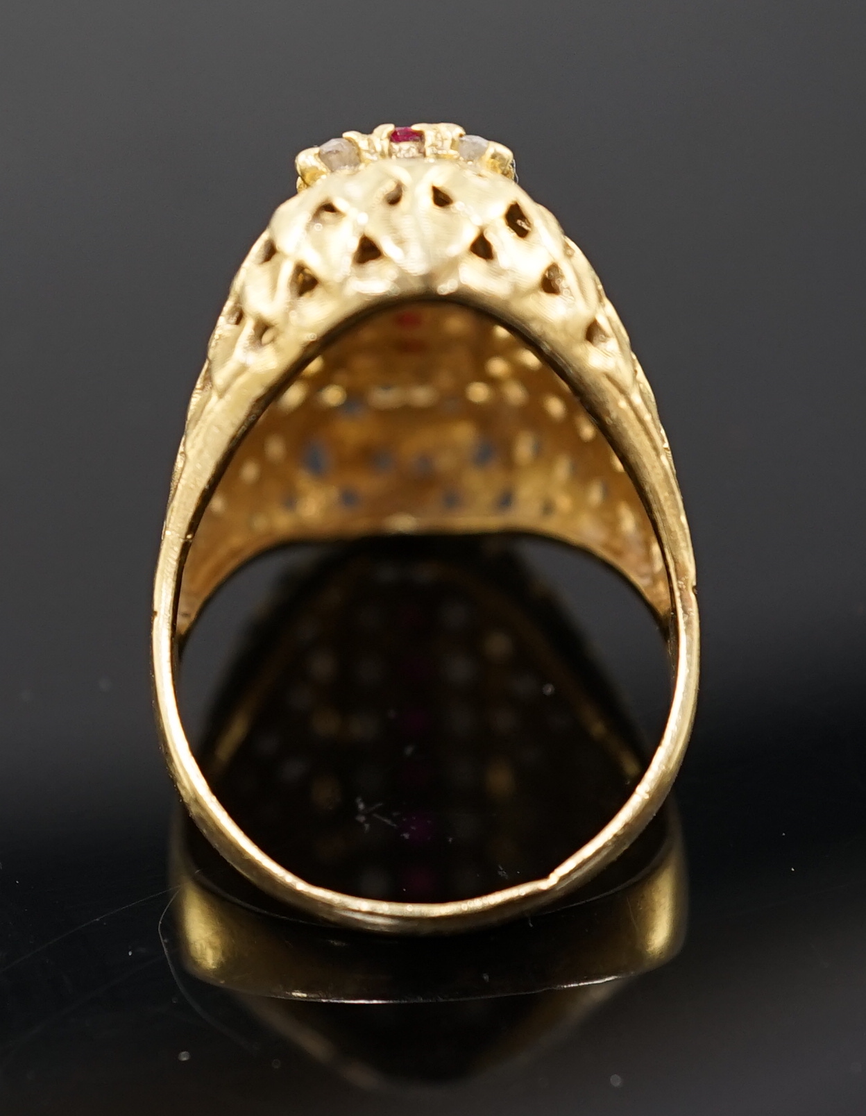 A modern 18ct gold and three row ruby and diamond cluster set pierced domed dress ring